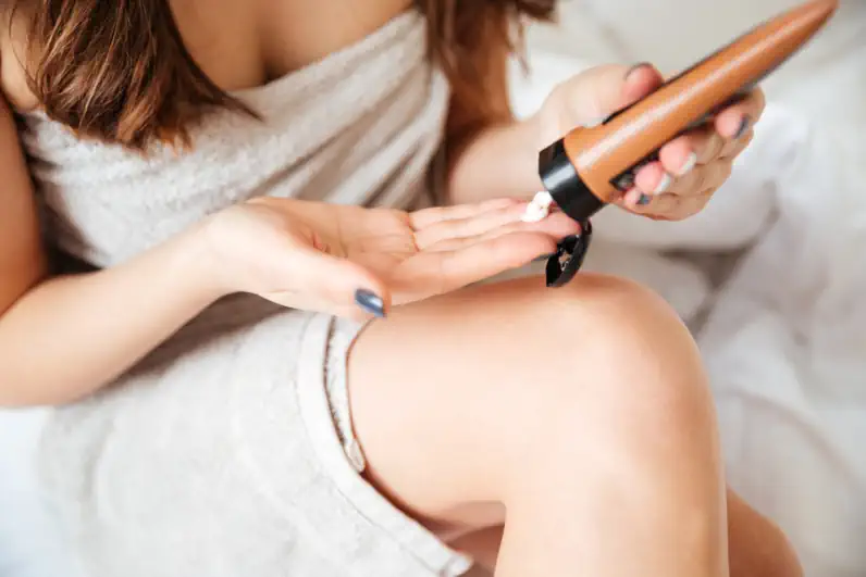 Woman Applying Moisturizer to Legs